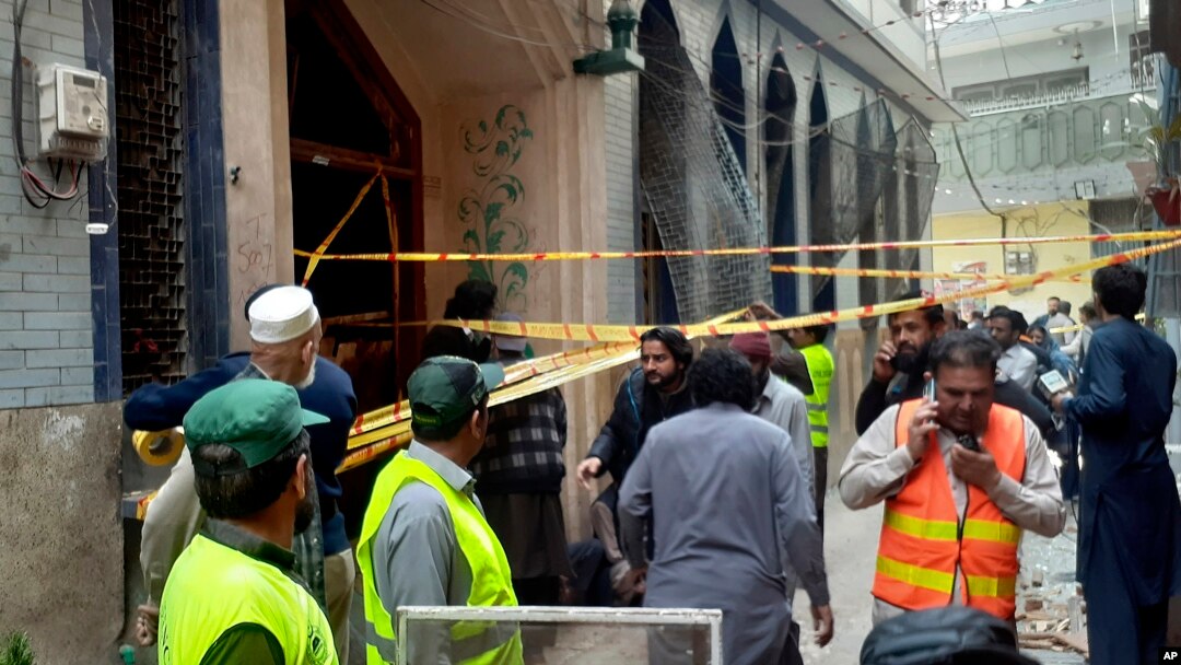 Rescue workers and volunteers gather at the site of bomb explosion in Peshawar, Pakistan, March 4, 2022.