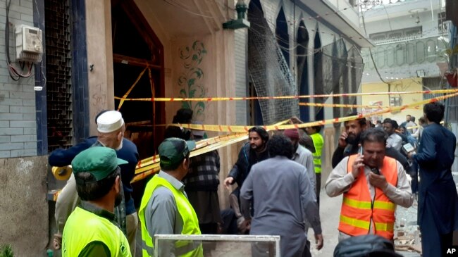 Petugas penyelamat dan relawan berkumpul di lokasi ledakan bom di Peshawar, Pakistan, 4 Maret 2022. (Foto: AP)