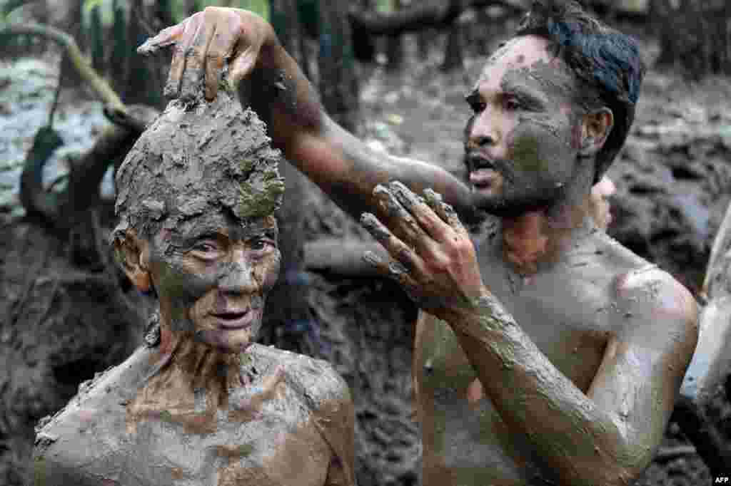 People take part in a mud bath tradition, known as Mebuug-buugan, held a day after Nyepi — the Balinese &quot;Day of Silence&quot; — aimed at neutralizing bad traits, in the village of Kedonganan on Indonesia&#39;s resort island of Bali