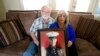 Joey dan Paula Reed berpose sambil membawa foto anak mereka yang ditahan di Rusia, Trevor, di rumah mereka di Fort Worth, Texas, pada 15 Februari 2022. (Foto: AP/LM Otero)