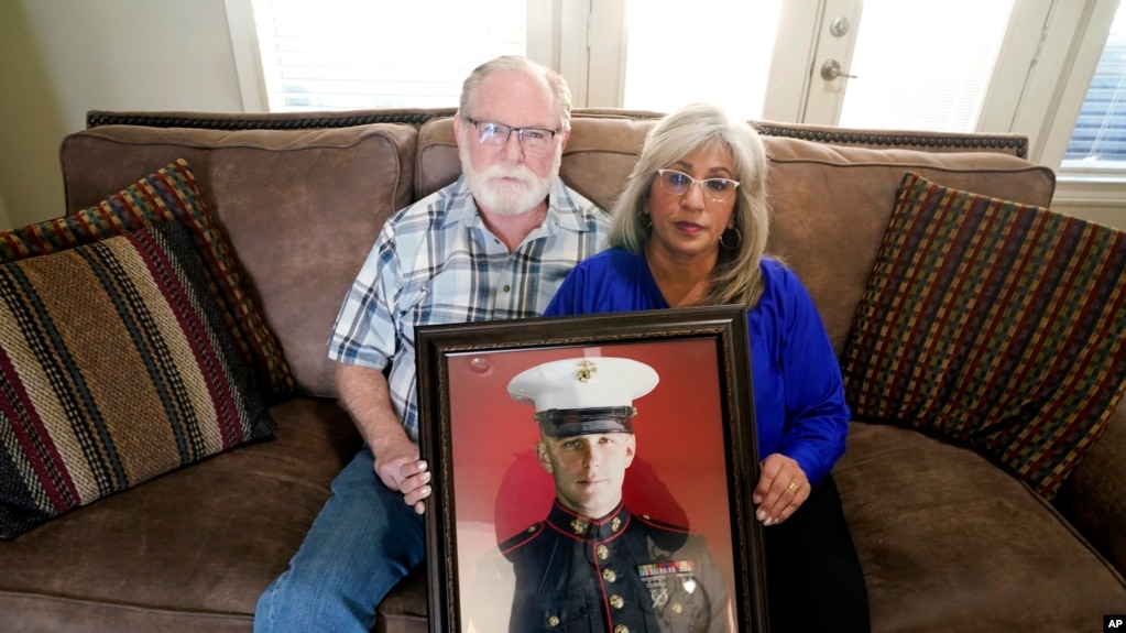 资料照：2022年2月15日，乔·里德和葆拉·里德在德克萨斯州沃斯堡的家中与他们的儿子、海军陆战队退伍军人特雷弗·里德的肖像合影。他们的儿子目前是俄罗斯的囚犯。（美联社）(photo:VOA)