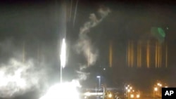 This image taken from a video released by the Zaporizhzhia Nuclear Power Plant shows a bright burning object landing on the grounds of the nuclear plant in Enerhodar, Ukraine, on Friday, March 4, 2022.
