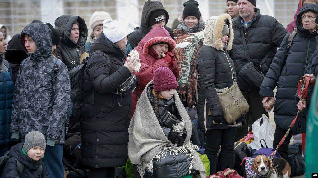 Las personas que salieron de Ucrania esperan un autobús que los lleve a la estación de tren en Przemysl, en el cruce fronterizo en Medyka, Polonia, el 4 de marzo de 2022.