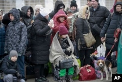 People who left Ukraine, wait for a bus to take them to the train station in Przemysl, at the border crossing in Medyka, Poland, March 4, 2022.