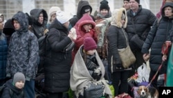 Orang-orang yang meninggalkan Ukraina, menunggu bus yang akan membawa mereka menuju stasiun kereta Przemysl, di wilayah perbatasan antara negara tersebut dengan Polandia, pada 4 Maret March 4, 2022.