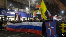 Demomstram sayap kanan Serbia membawa bendera Rusia dan mencoret bendera NATO dalam unjuk rasa di Beograd, Jumat (3/3).