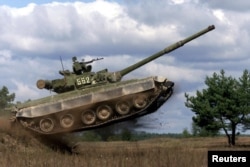 FILE - An Ukrainian T-80UD tank jumps during a show at Desna firing ground near Kyiv, Sept. 22, 2000.