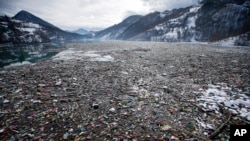 FILE - Plastic bottles and other garbage float in Potpecko lake near Priboj, in southwest Serbia on Jan. 22, 2021. The U.N. Environment Assembly (UNEA) unanimously voted Wednesday, March 2, 2022 in Nairobi, Kenya to start to create a legally binding global treaty to address plastic pollution in the world's oceans, rivers and landscape. (AP Photo/Darko Vojinovic, File)