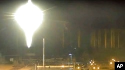 Esta imagen tomada de un video publicado por la planta de energía nuclear de Zaporizhzhia muestra un objeto brillante en llamas aterrizando en los terrenos de la planta nuclear en Enerhodar, Ucrania, el 4 de marzo de 2022.