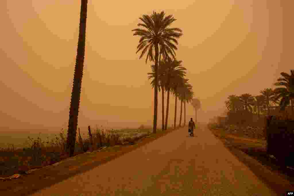 A man walks along a road during a sand storm in Iraq&#39;s southern port city of Basra.