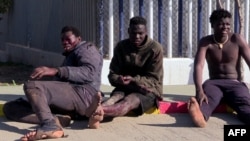 FILE: This video grab shows an injured migrant (L) after arriving with others at the Temporary Center for Immigrants and Asylum Seekers (CETI) in Melilla after jumping the border fence separating Spain's Melilla enclave from Morocco on March 2, 2022. 