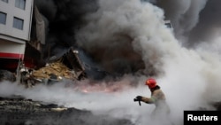 Seorang petugas berusaha memadamkan kebakaran pasca serangan Rusia terhadap Desa Chaiky, di kawasan Kyiv, Ukraina (3/3). 