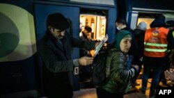 Біженці з України на залізничному вокзалі в Бухаресті, березень 2022 року