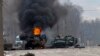 A Russian armored personnel carrier burns amid damaged and abandoned light utility vehicles after fighting in Kharkiv, Ukraine, Feb. 27, 2022. 
