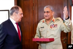 FILE - In this handout photo released by Russian Foreign Ministry Press Service, Russian Foreign Minister Sergey Lavrov, left, listens to Pakistan's Army Chief Gen. Qamar Javed Bajwa during their meeting in Islamabad, Pakistan, April 7, 2021.