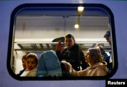 A man waves on the train at the station after fleeing Russian invasion of Ukraine, in Przemysl, Poland, March 1, 2022.