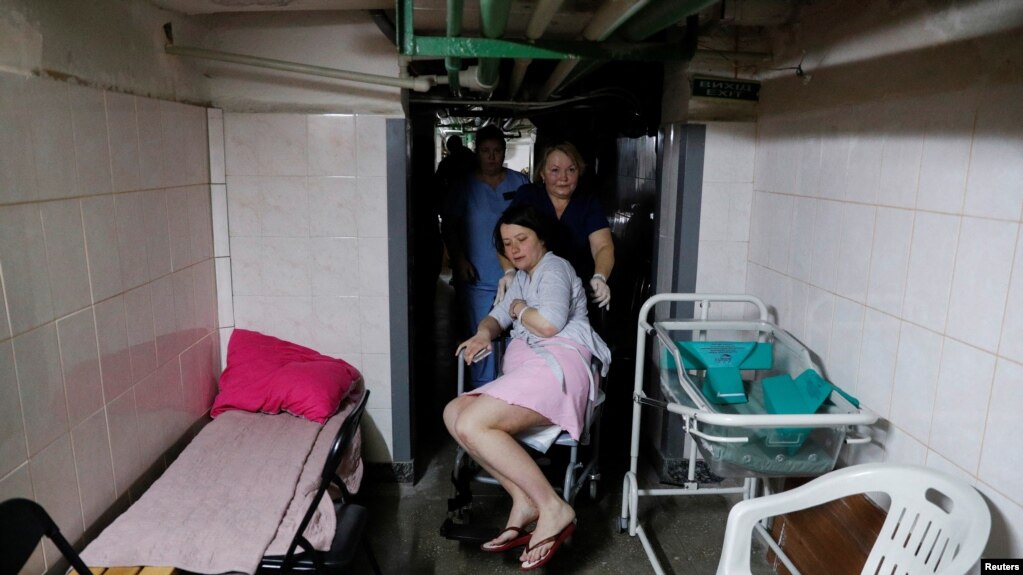2022年3月2日，在俄罗斯入侵乌克兰期间，乌克兰基辅响起空袭警报声，护士帮助一名患者在围产中心的地下室避难。（路透社）(photo:VOA)