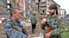 FILE - Russian special police unit officers talk to each other in downtown Grozny, Chechnya, as a Chechen man passes, March 2001.