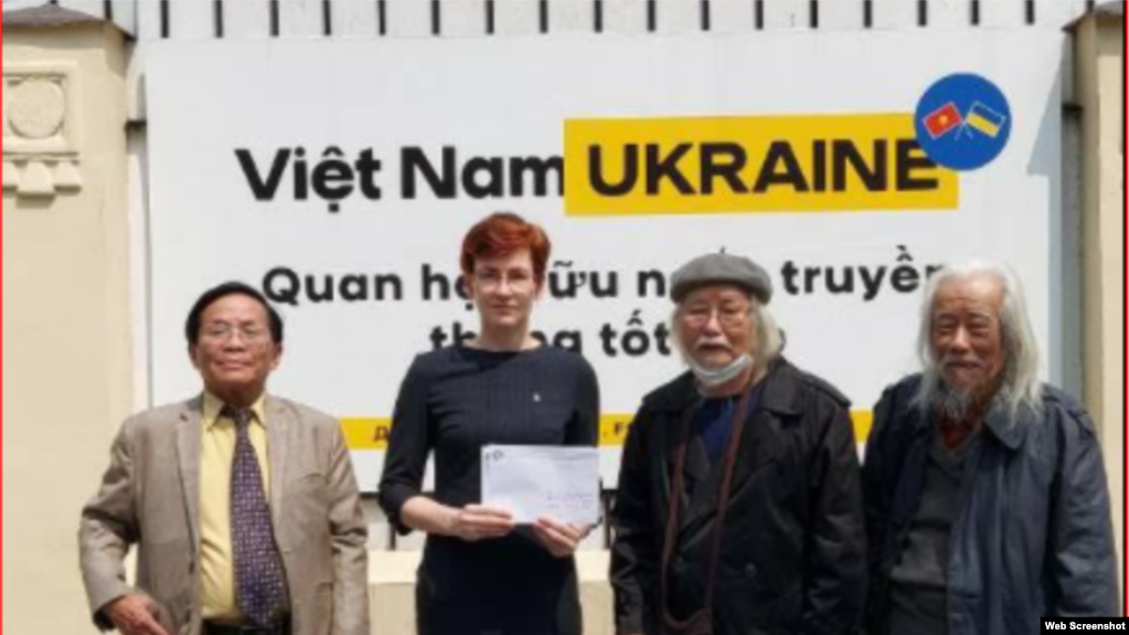 越南文化研究员阮克梅（右二）和阮廷贡教授（右一）等人向乌克兰驻河内大使馆临时代办纳塔利娅·日基娜(Nataliya Zhynkina)（左二）递交表达他们“支持乌克兰人民”的信（照片由Bovitvn提供）。(photo:VOA)