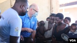 FILE - UNCEF's Rudolf Schwenk, second left, talks with mothers displaced by floods at Bangula evacuation camp in the Nsanje district, Malawi, Feb. 8, 2022. Authorities say the polio vaccine will reach children in evacuation camps. (Lameck Masina/VOA)