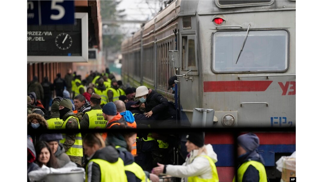 Autoridades y activistas reciben a refugiados ucranianos en la estación de trenes de Przemysl, en Polonia, el 3 de marzo de 2022.