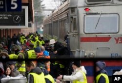 Autoridades y activistas reciben a refugiados ucranianos en la estación de trenes de Przemysl, en Polonia, el 3 de marzo de 2022.