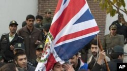 Protesters remove the flag of the British embassy in Tehran, November 29, 2011.