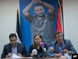 FILE - Fadwa Barghouti, center, with a picture of her husband Marwan Barghouti, and Qadoura Fares, right who heads an advocacy group for Palestinian prisoners hold a press conference, in the West Bank city of Ramallah, May 7, 2017.
