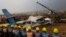 FILE- In this Monday, March 12, 2018 file photo, Nepalese rescuers and police are seen near the debris after a passenger plane from Bangladesh crashed at the airport in Kathmandu.