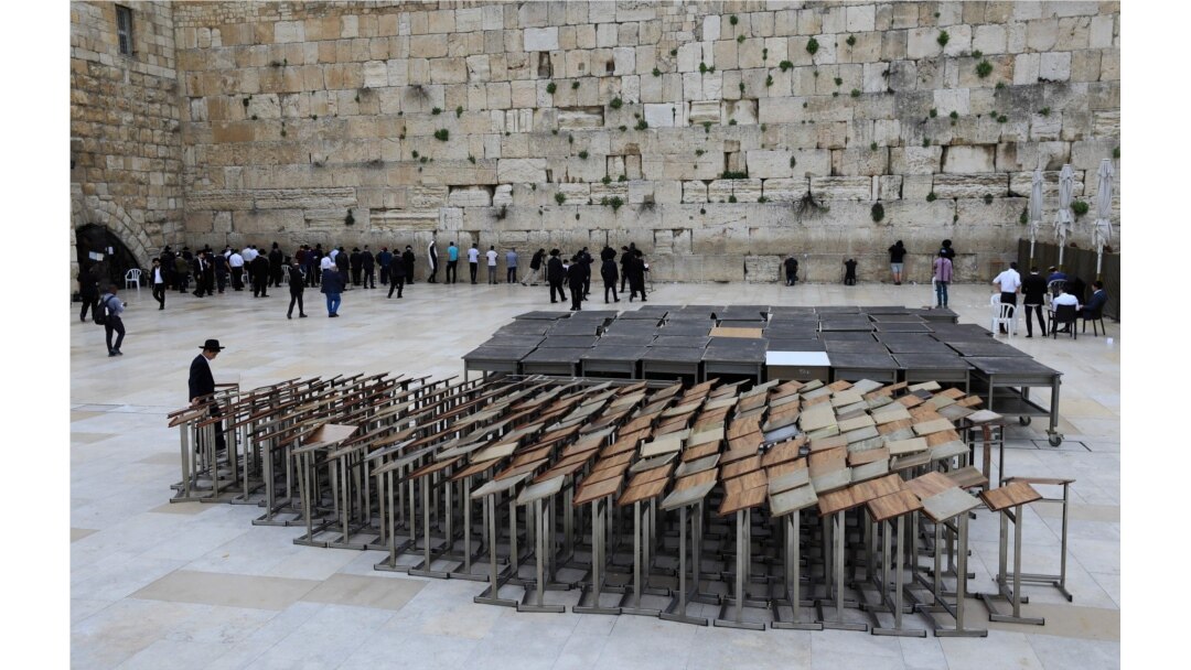An ultra-Orthodox Jew stands past praying pulpits at the nearly deserted Western Wall, Judaism's holiest site, after Israel has imposed some of the world's tightest restrictions to contain COVID-19 coronavirus disease, in Jerusalem, March 12, 2020.