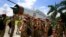 Students gather by an inactive fighter aircraft on display at a Sainik School, or military school, in Goalpara, in the northeastern Indian state of Assam, Aug. 8, 2014.