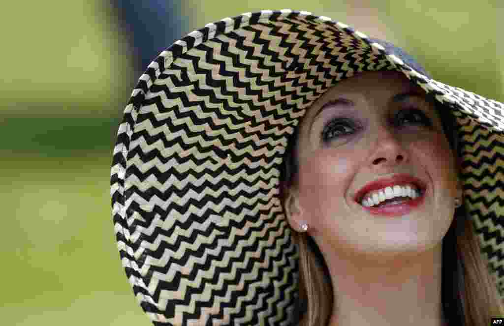 A racegoer waits for the next horse race on Ladies Day at the Epsom Derby Festival, in Surrey, southern England.