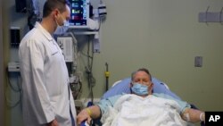 FILE - A doctor speaks to a patient in an emergency room at Northside Hospital in Cumming, Georgia, Jan. 29, 2018.