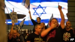 Israelis block a highway during a protest after Prime Minister Benjamin Netanyahu dismissed his popular Defense Minister Yoav Gallant, in Tel Aviv, Israel, Nov. 5, 2024. 