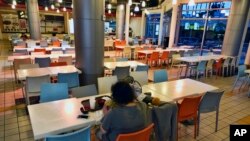 A customer eats a bowl of soup at a deserted food court in the Koreatown section of Los Angeles, Feb. 27, 2020.