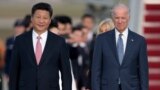 FILE - In this Sept. 24, 2015 file photo, Chinese President Xi Jinping and Vice President Joe Biden walk down the red carpet on the tarmac during an arrival ceremony in Andrews Air Force Base, Md.