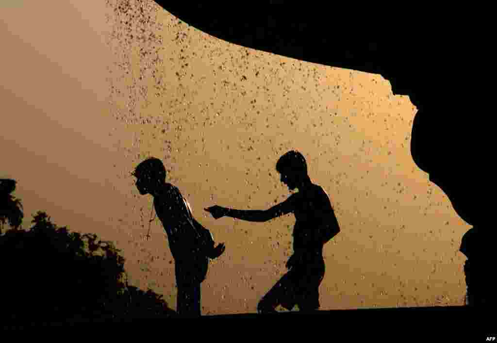 May 3: Indian children cool themselves at a water fountain on a hot afternoon in New Delhi. (AP Photo/Tsering Topgyal)