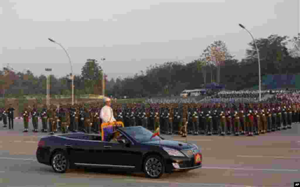 Myanmar's President Thein Sein, standing in an open vehicle, inspect officers and soldiers during a ceremony to mark Myanmar's 67th anniversary of Independence Day in Naypyitaw, Myanmar, Sunday, Jan. 4, 2015. (AP Photo/Gemunu Amarasinghe)