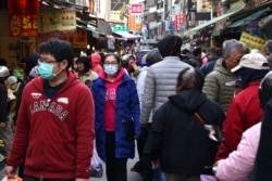 Customers wear protective masks to prevent the spread of the coronavirus disease while shopping at a market in Taipei, Taiwan, Jan. 10, 2021.