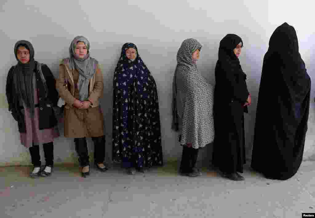 Afghan women wait in line to receive their voter registration cards in Kabul for the Afghan presidential elections scheduled for April 5.