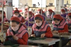 지난달 6일 북한 평양의 방직공장 종업원들이 마스크를 쓴 채 작업하고 있다.
