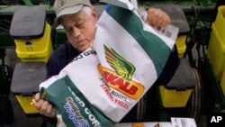 FILE - Central Illinois corn and soybean farmer Gary Niemeyer readies his DEKALB seed corn for spring planting at his farm near Auburn, Ill., April 4, 2011. German drug and chemicals company Bayer AG announced Monday that it has made a $62 billion offer to buy U.S.-based crops and seeds specialist Monsanto. 
