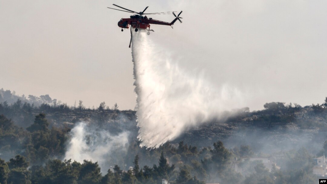 Sebuah helikopter menjatuhkan air untuk memadamkan kebakaran hutan (foto: ilustrasi). 