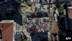 Vista aérea tomada el 1 de noviembre de 2020, muestra voluntarios y rescatistas buscando sobrevivientes en un edificio colapsado en Esmirna, Turquía, luego de un poderoso terremoto que afectó también partes de Grecia.