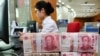 2018年7月23日在中国江苏省南通市的一家银行，一名员工处理100元纸币。