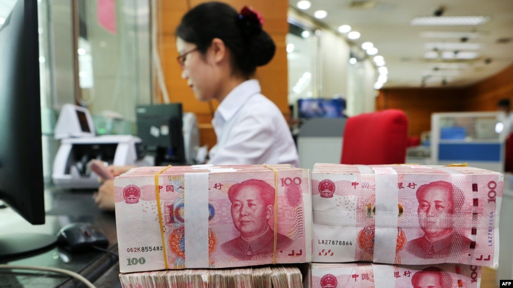 在中國江蘇省南通市的一家銀行，一名員工處理100元紙幣。（2018年7月23日）