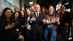 French President Emmanuel Macron poses with employees during a visit to the Plaine Images industry hub in Tourcoing, northern France, Nov. 14, 2017.