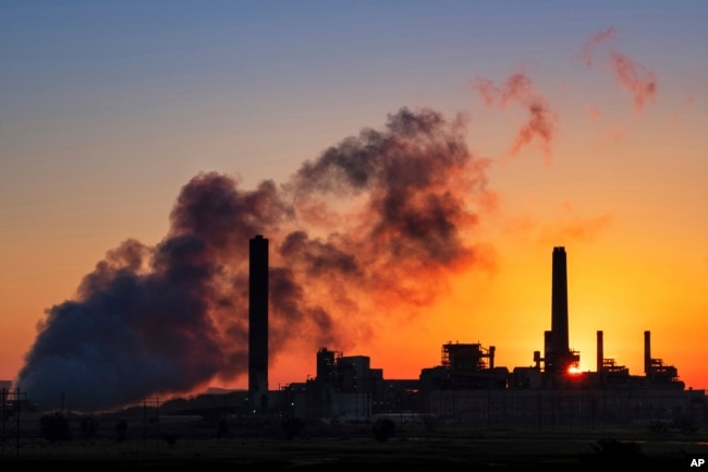 FILE - the Dave Johnson coal-fired power plant is silhouetted against the morning sun in Glenrock, Wyo.