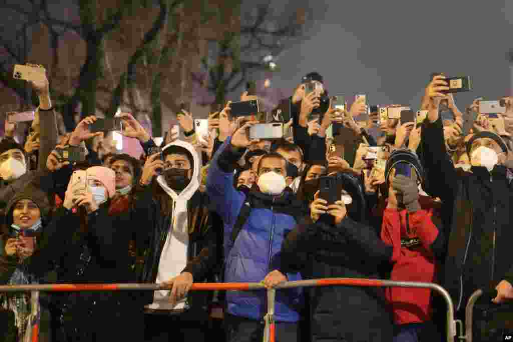 Spectators at the boulevard Unter den Linden use their mobile devices as they celebrate the New Year near the Brandenburg Gate in Berlin, Germany, Jan. 1, 2022.