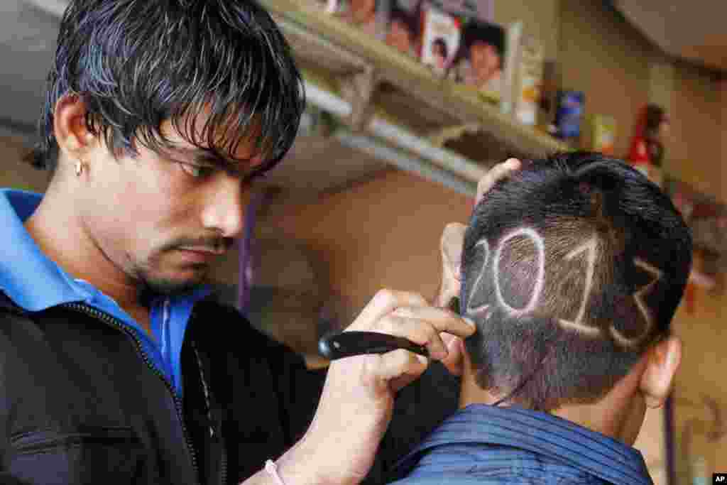 An Indian barber gives finishing touches to the hair style of a young boy with numbers to welcome the New Year 2013 in Ahmadabad, India, December 31, 2012. 